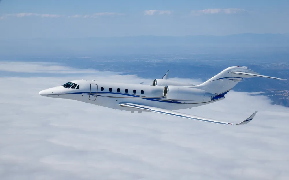 Private jet flying over clouds