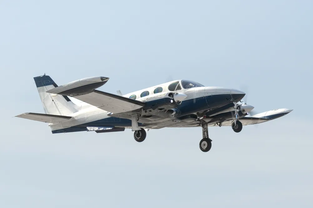 Small twin-engine plane flying in clear sky