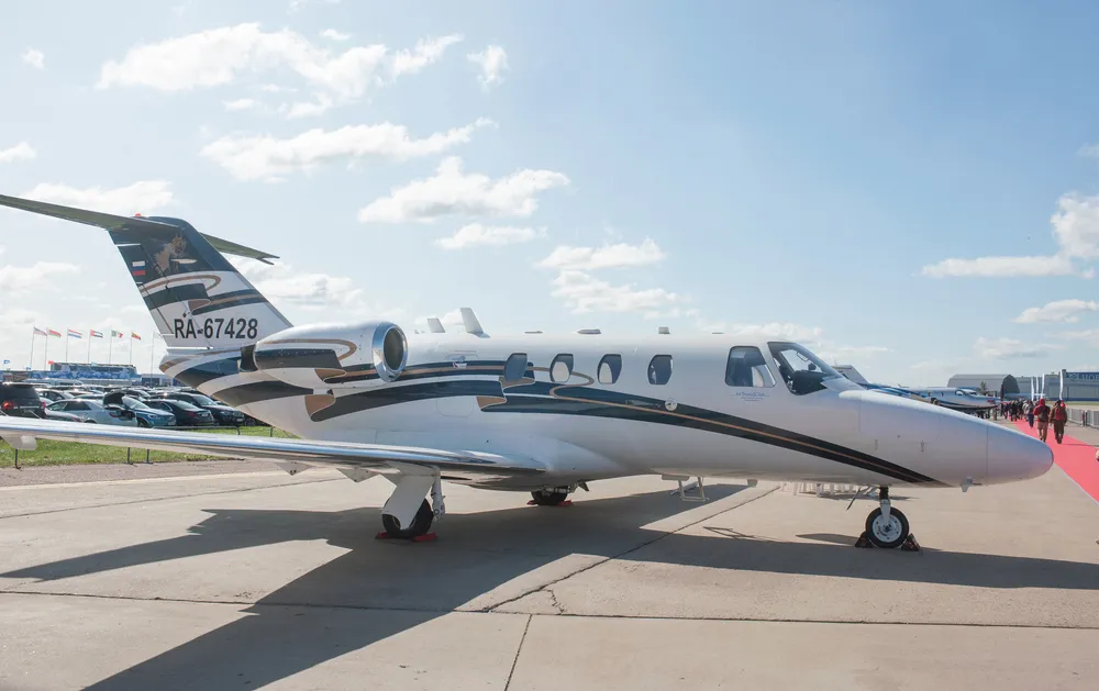 Private jet parked on airport tarmac.